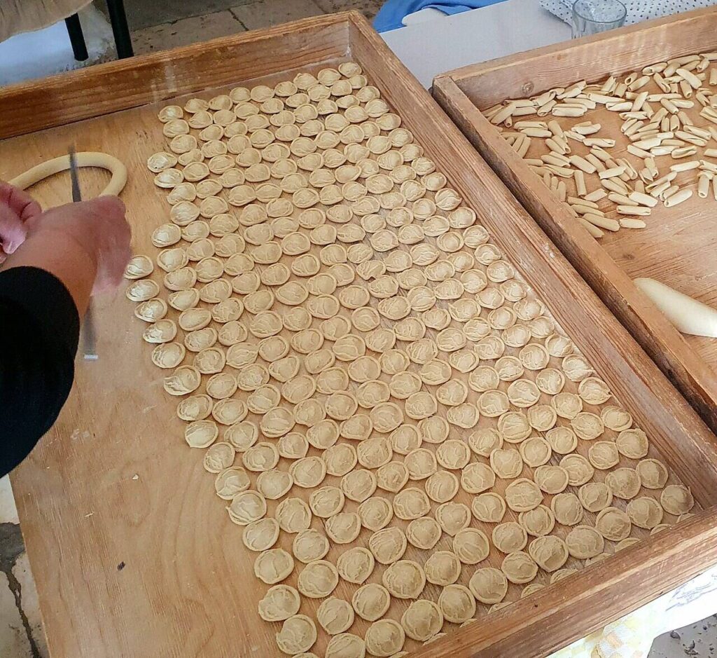 Orecchiette fatte a mano su una spianatoia di legno