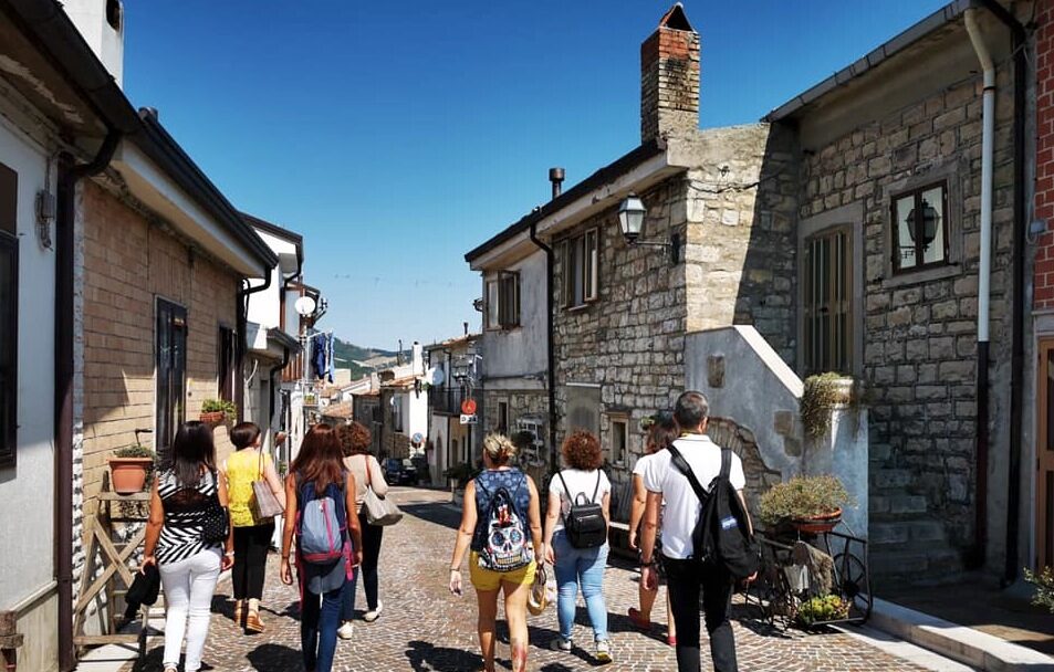 Visitatori a passeggio tra le case in pietra di Celle di San Vito